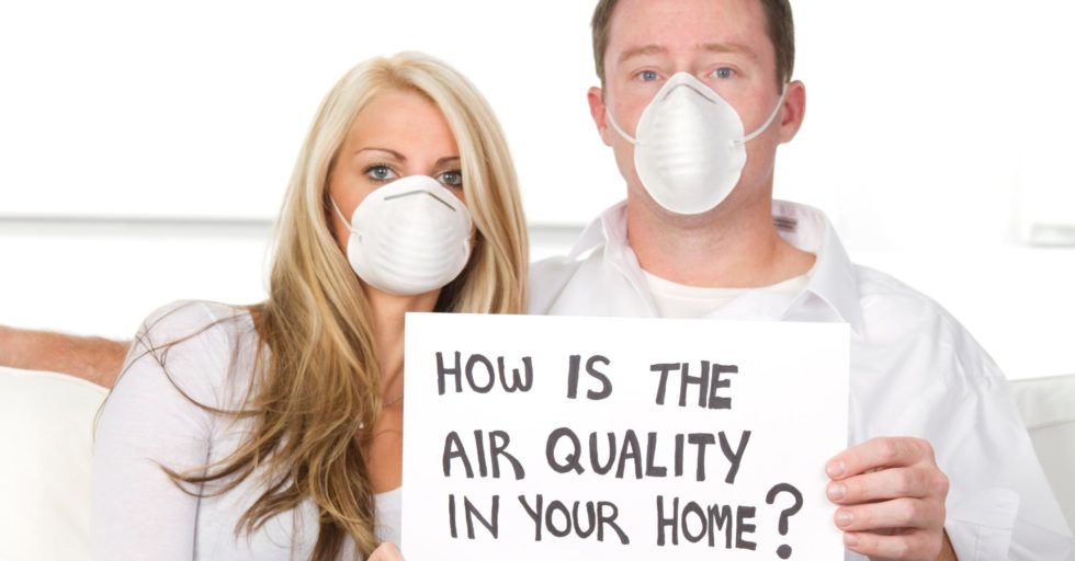 A couple wearing masks inside their home